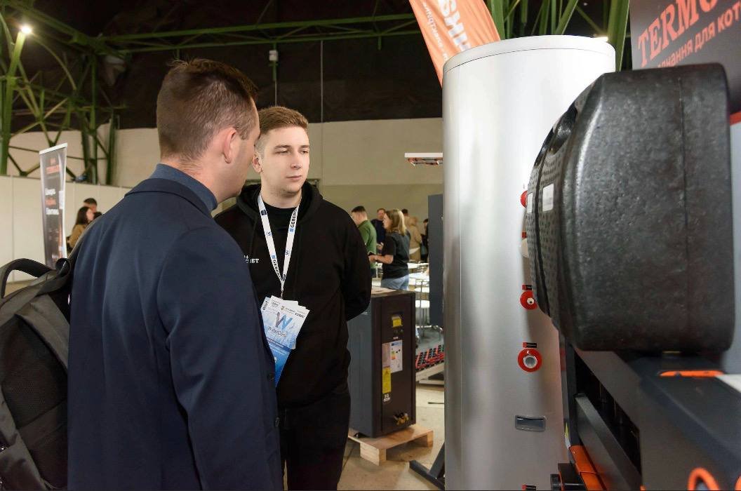 A consultation at the Termojet stand: a stainless steel cylinder and a pump group